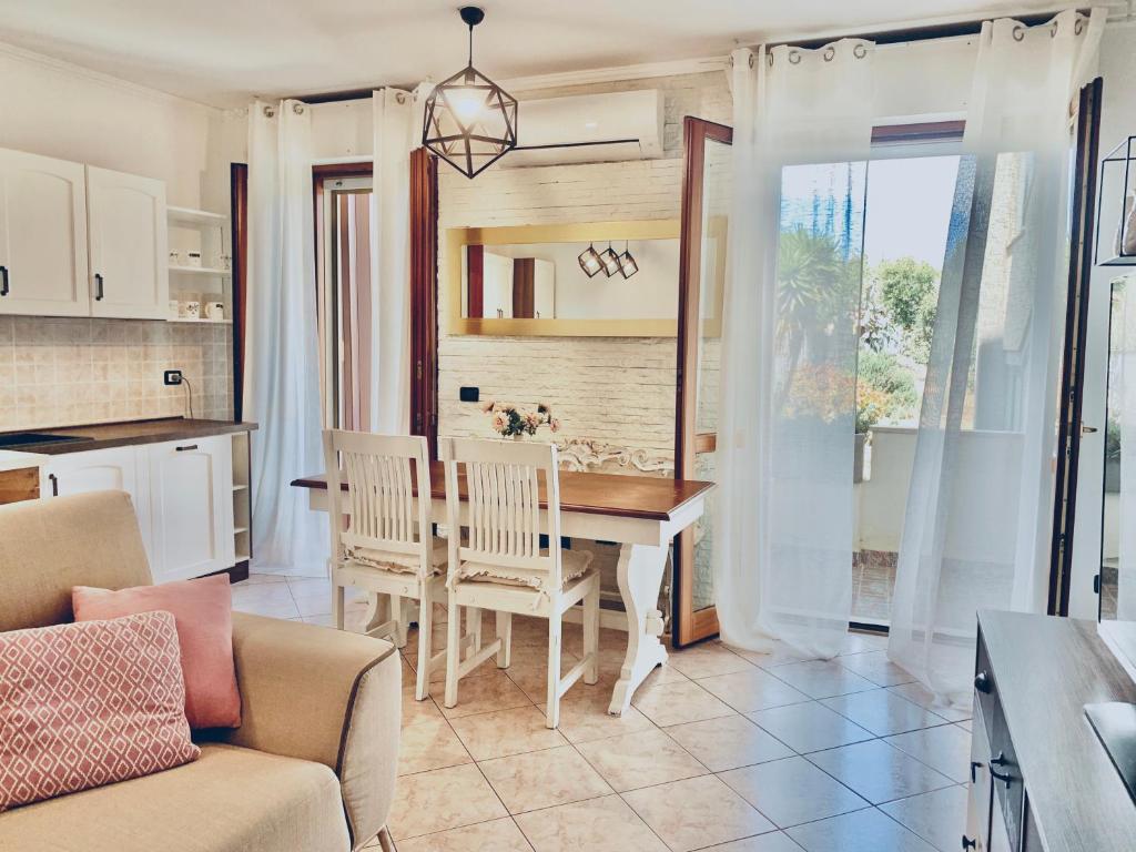 a kitchen and dining room with a table and chairs at Eleonora Home in Porto Torres