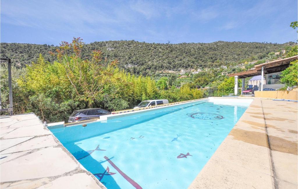 une grande piscine bleue avec une montagne en arrière-plan dans l'établissement 2 Bedroom Gorgeous Apartment In Falicon, à Falicon