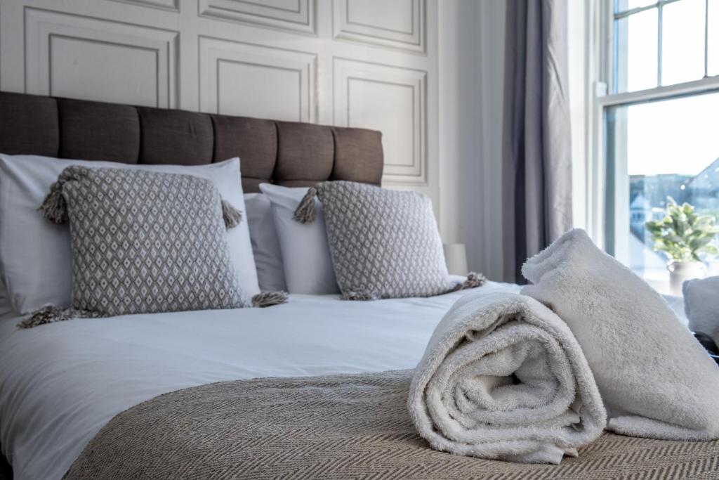 ein Schlafzimmer mit einem Bett mit einer Decke darauf in der Unterkunft Croft Road Apartments in Neath