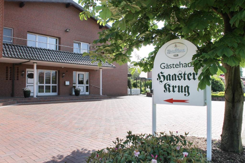 ein Schild vor einem Backsteingebäude in der Unterkunft Hotel garni Haaster Krug Otte in Großenkneten