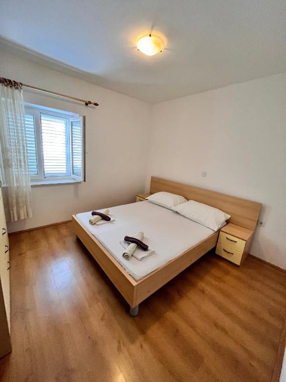 sypialnia z dużym łóżkiem i drewnianą podłogą w obiekcie Apartment Metajna 6465a w mieście Metajna