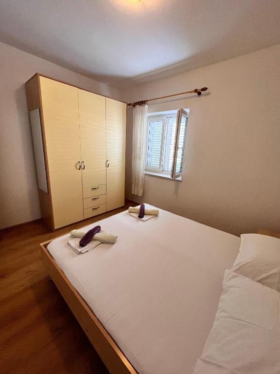sypialnia z dużym białym łóżkiem i oknem w obiekcie Apartment Metajna 6465a w mieście Metajna