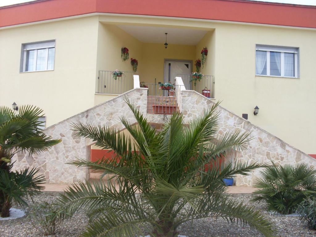 a house with a staircase and palm trees in front of it at Villa Mafalda in Martina Franca