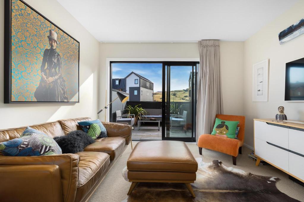 a living room with a couch and a chair at Remarkables Retreat Apartment in Queenstown