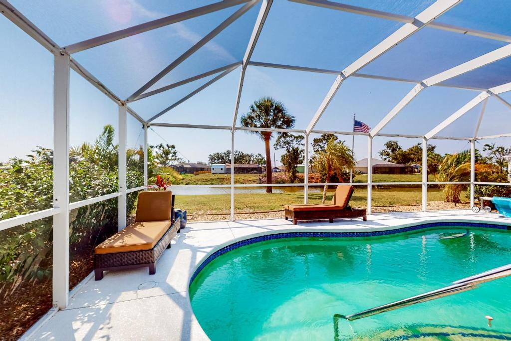 einen Pool mit zwei Stühlen und einem Pavillon in der Unterkunft Snow We're Not in Englewood