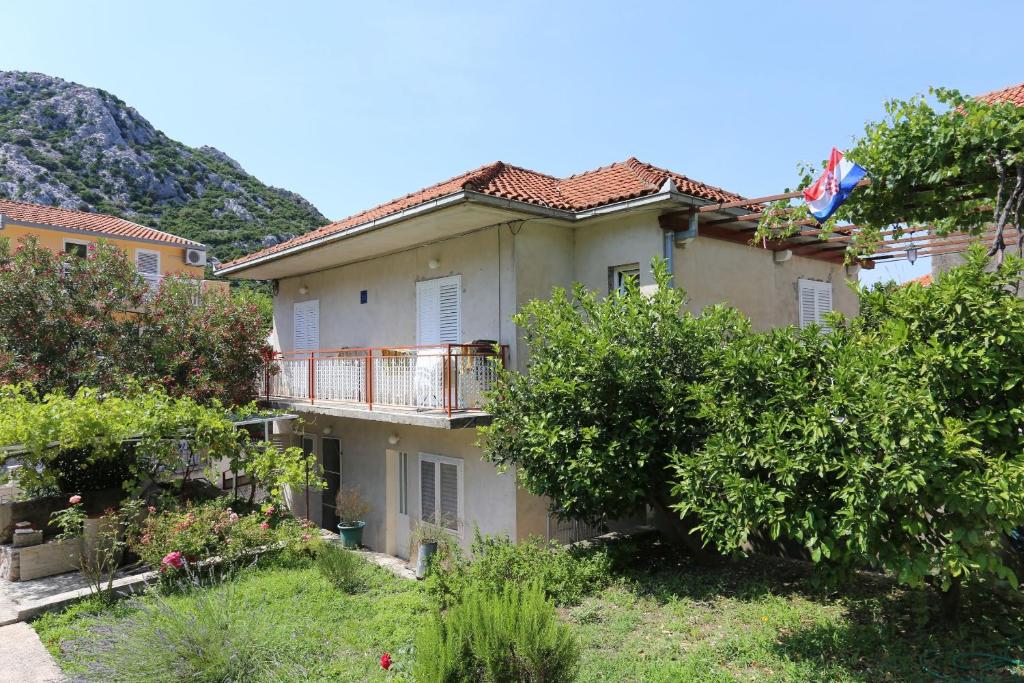 een appartementencomplex met een balkon en bomen bij Holiday apartments Duba Peljeska, Peljesac - 10231 in Trpanj