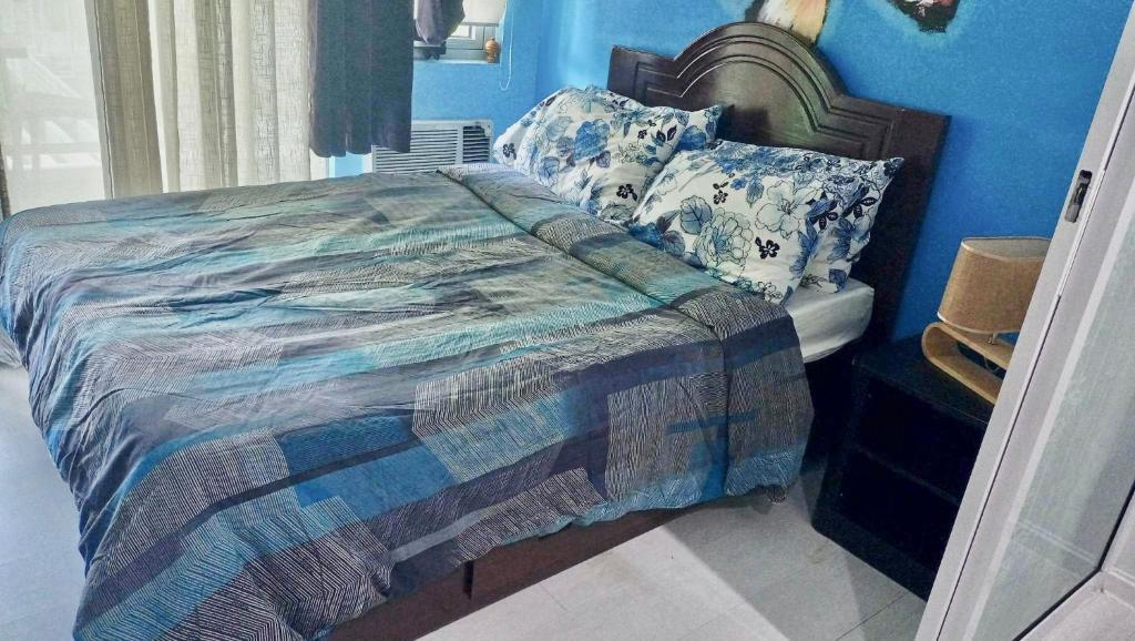 a bedroom with a bed with a blue wall at Azure - Acqua Apartments in Manila