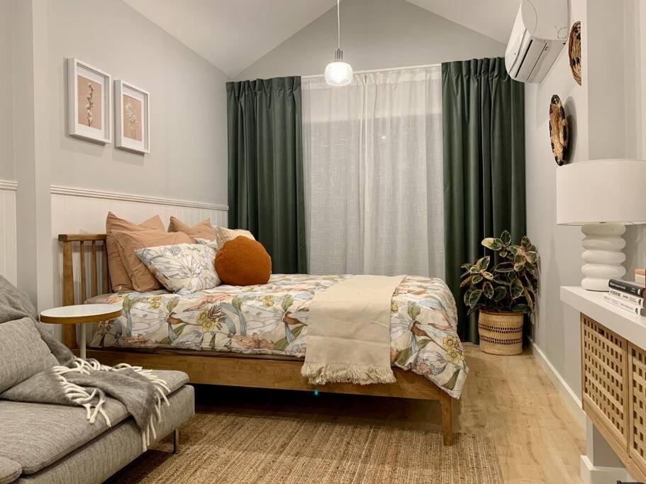 1 dormitorio con 1 cama y 1 sofá en Stylish Geelong Cabin - Your home away from home, en Belmont