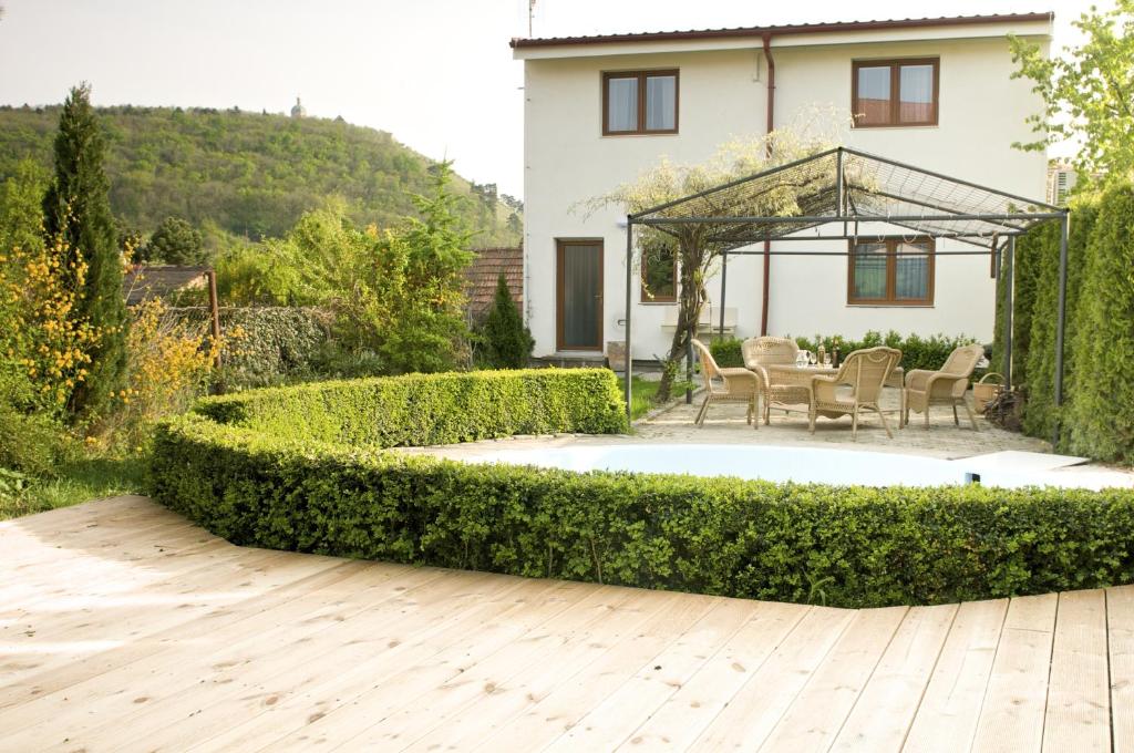 un jardín con jacuzzi frente a una casa en Pension Archa Mikulov, en Mikulov