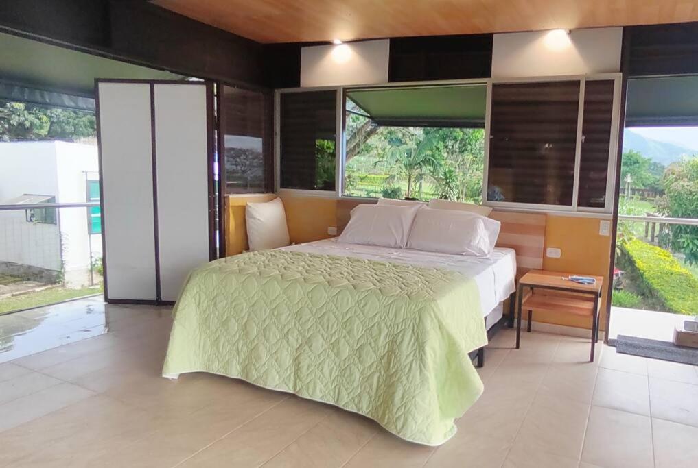 - une chambre avec un lit et une grande fenêtre dans l'établissement Comfortable glamping loft with pool and vineyards, à Rivera