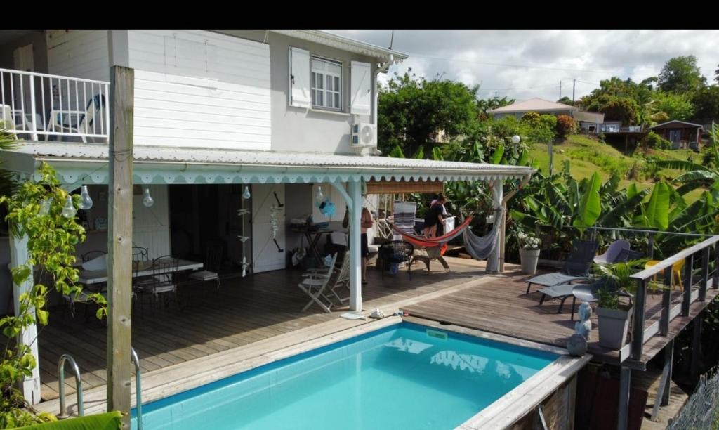 a house with a deck and a swimming pool at CHARMANT HAUT DE VILLA AVEC PISCINE PARTAGEE in Le Vauclin