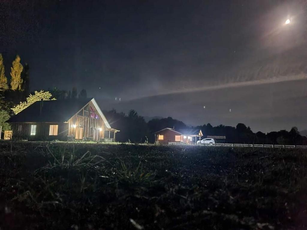 a house in a field at night at Cabañas Antü Küyen Melipeuco in Melipeuco