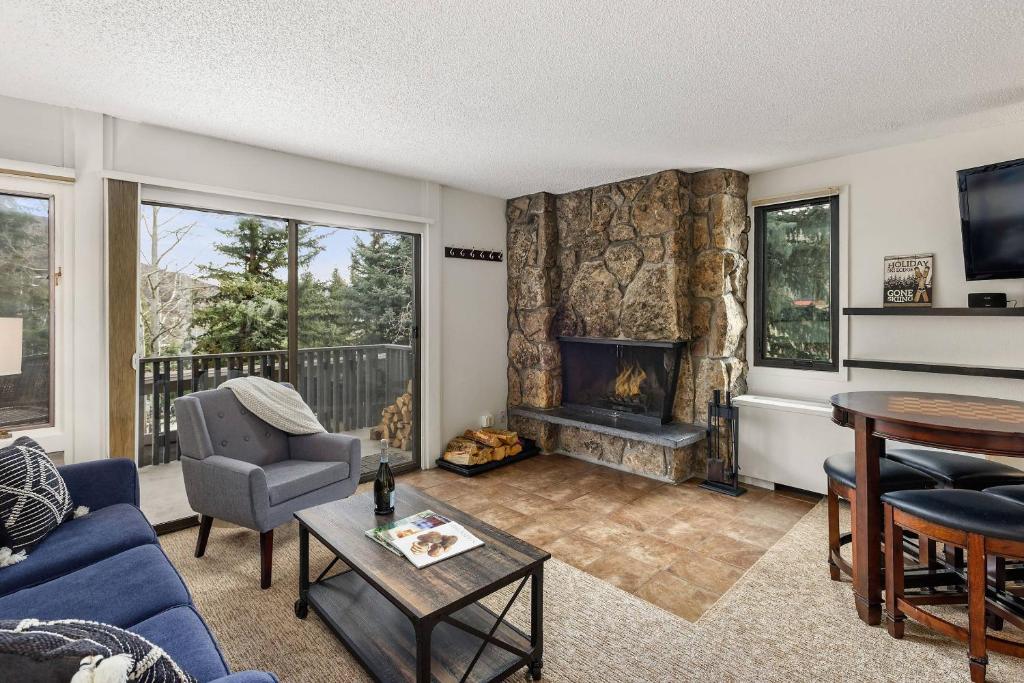 a living room with a blue couch and a fireplace at Lichenhearth 21 in Snowmass Village