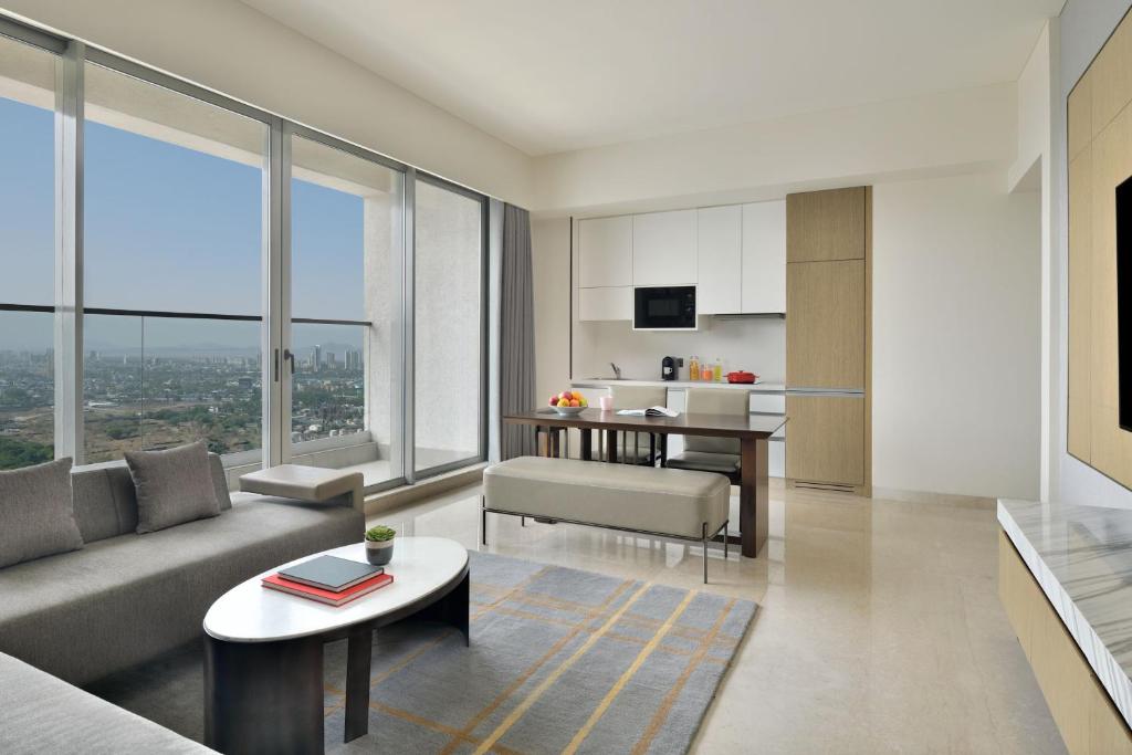 uma sala de estar com um sofá e uma mesa em Marriott Executive Apartments Navi Mumbai em Navi Mumbai