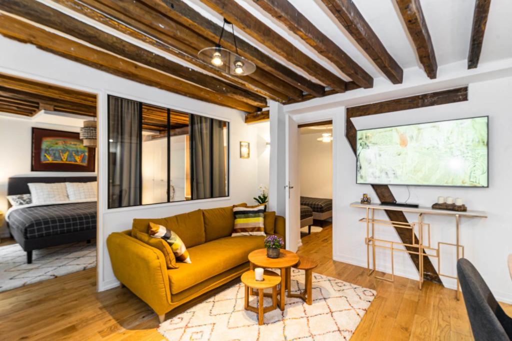 een woonkamer met een gele bank en een flatscreen-tv bij Opéra-Madeleine 2 bedrooms in Parijs