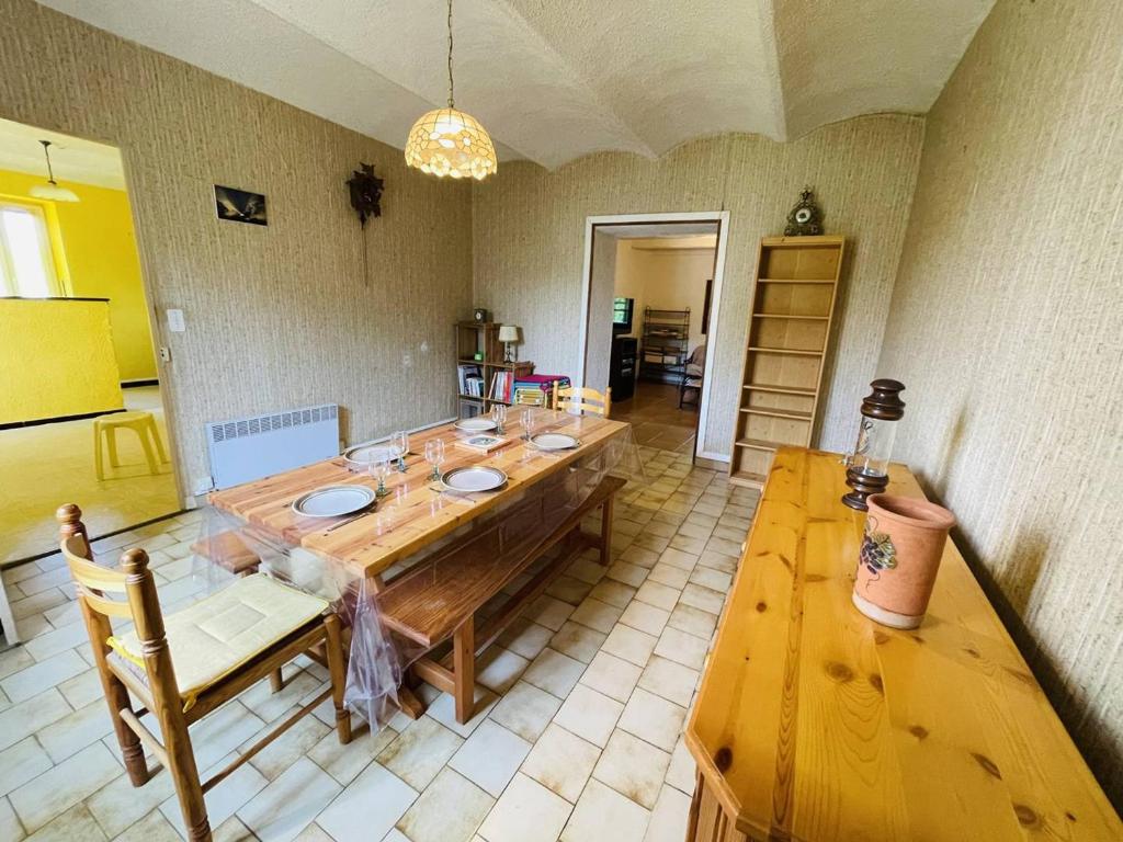 a dining room with a wooden table and a tableasteryasteryasteryasteryasteryastery at Maison Pradons, 4 pièces, 6 personnes - FR-1-697-24 in Pradons