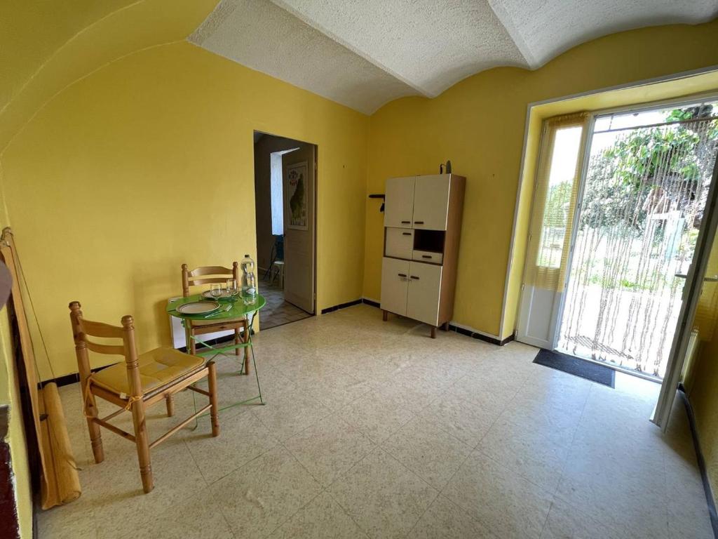 a kitchen with a table and chairs and a refrigerator at Maison Pradons, 4 pièces, 6 personnes - FR-1-697-24 in Pradons