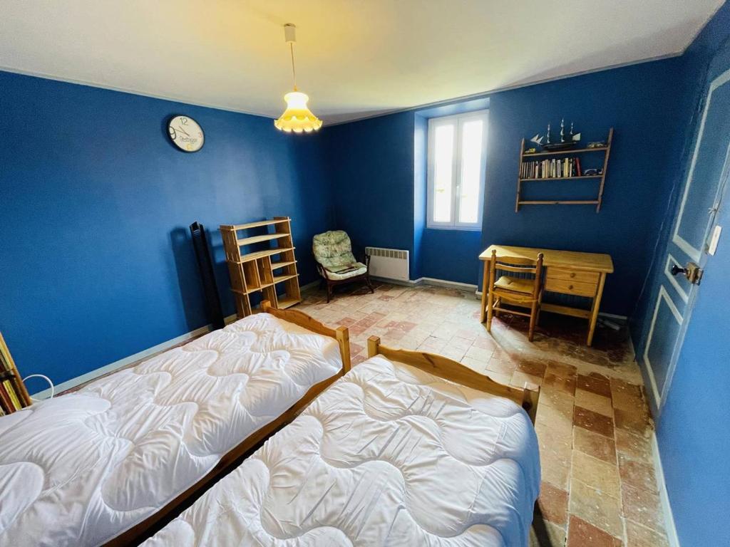 a bedroom with a bed and a blue wall at Maison Pradons, 4 pièces, 6 personnes - FR-1-697-24 in Pradons