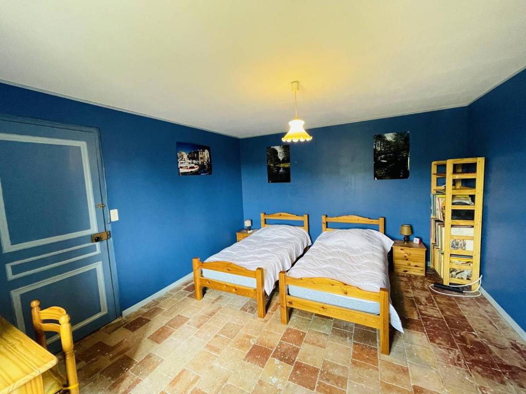 a bedroom with two beds and a blue wall at Maison Pradons, 4 pièces, 6 personnes - FR-1-697-24 in Pradons