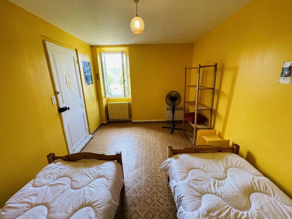 two beds in a room with yellow walls at Maison Pradons, 4 pièces, 6 personnes - FR-1-697-24 in Pradons
