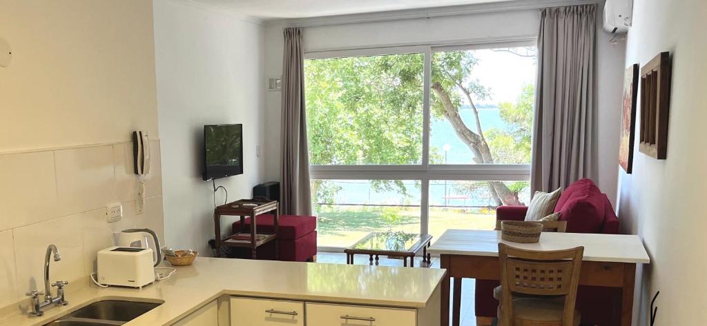 a kitchen with a large window and a table with chairs at Atardeceres Chascomús in Chascomús