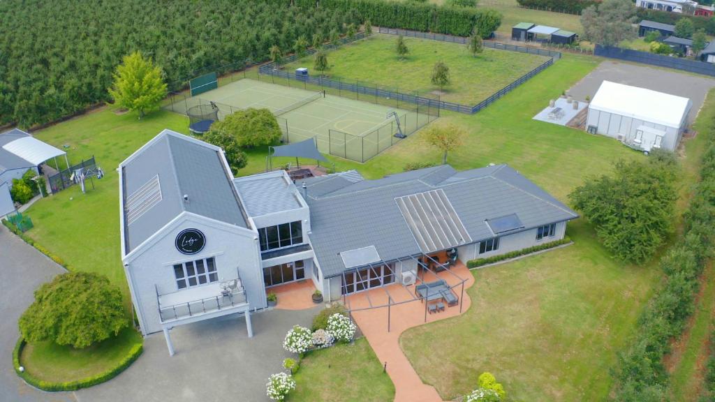 an aerial view of a house with a tennis court at Lodge On St Georges in Havelock North