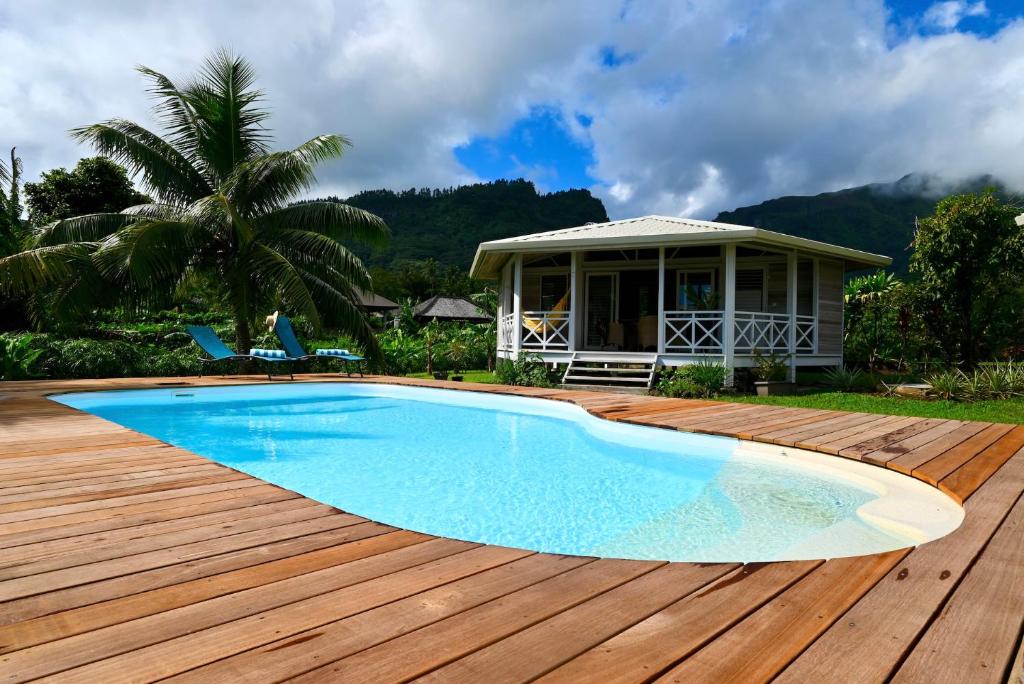 una piscina en una terraza de madera junto a una casa en FARE VAVAE, en Tevaitoa