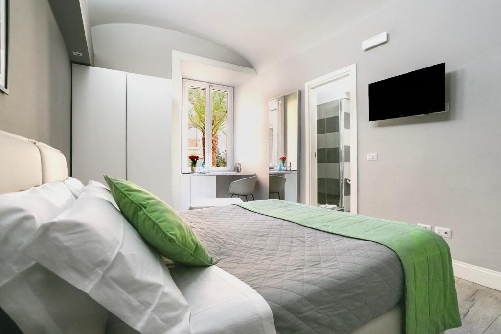 ローマにあるScipioni Best Roomsのベッドルーム(緑の枕とテレビ付)