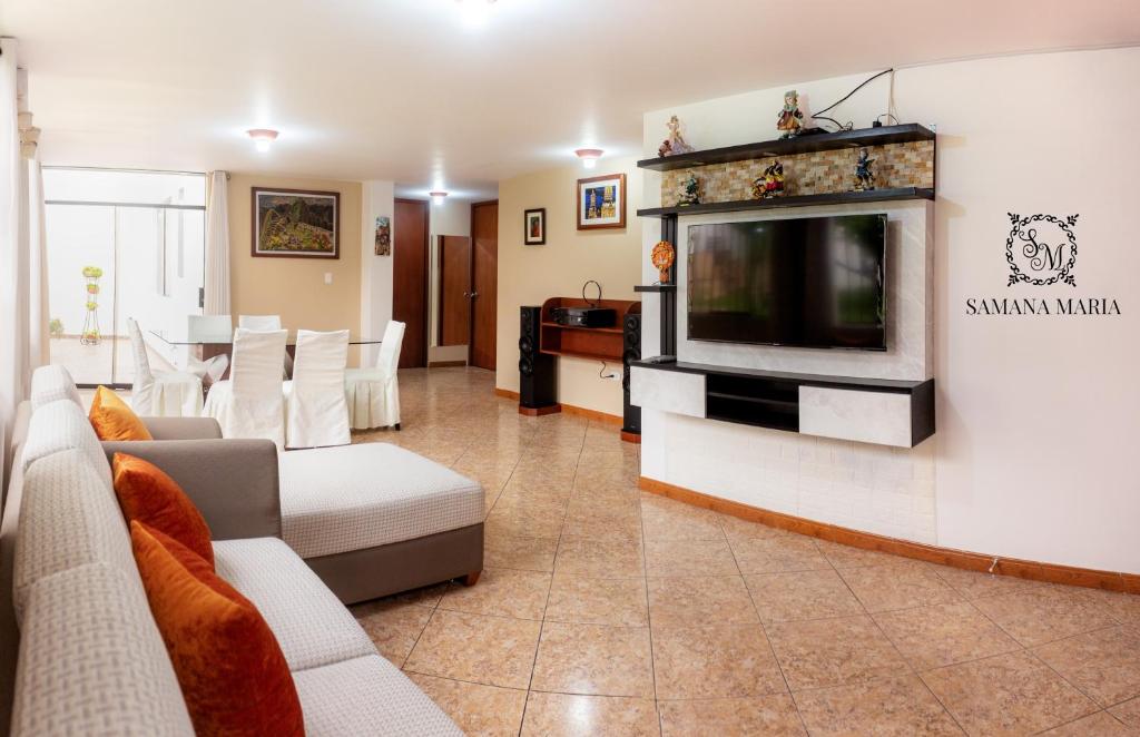 een woonkamer met een bank en een tv bij SSAMANA MARÍA APARTMENT 102 in Arequipa