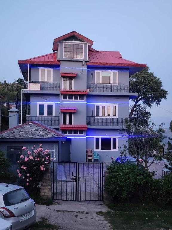 a blue house with a fence in front of it at A.R . Homestay in Shimla