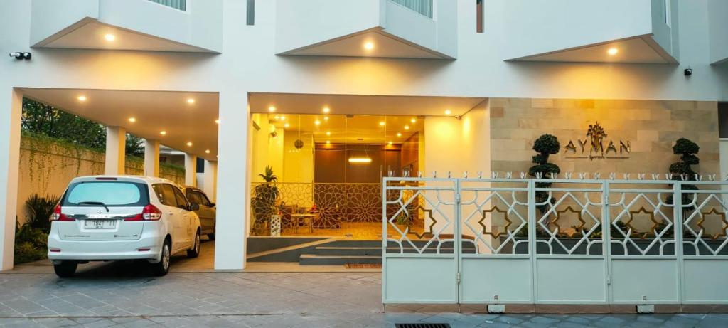 a white car parked in front of a building at AYMAN SYARIAH HOTEL in Surabaya