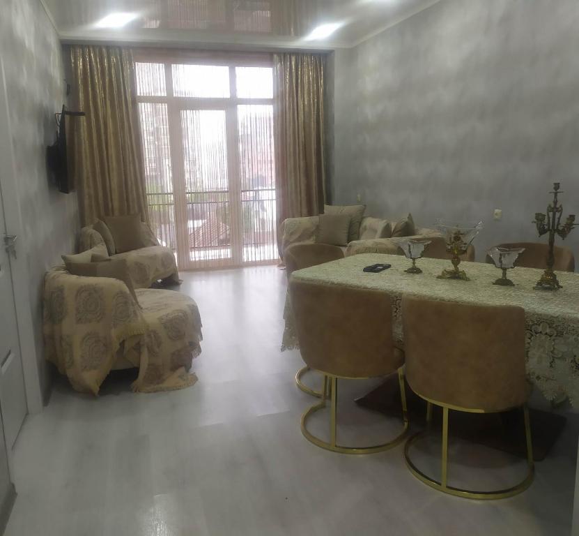 Family apartament في باتومي: غرفة معيشة مع طاولة وكراسي وأريكة