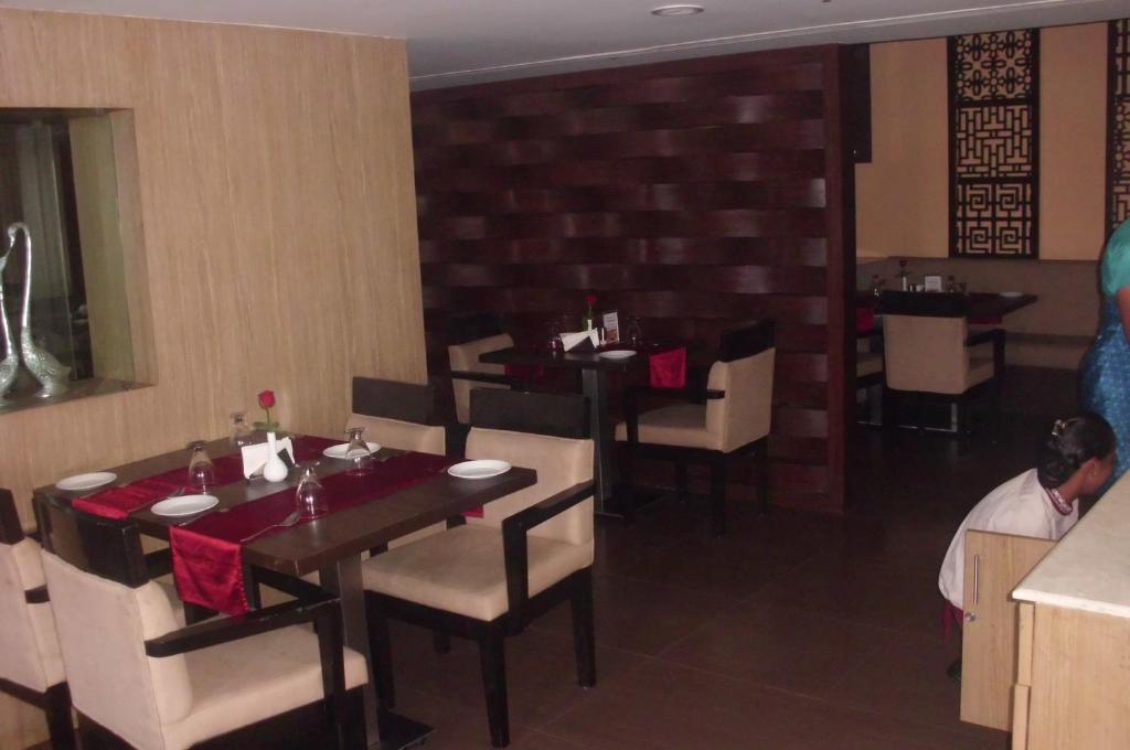 a dining room with tables and chairs in a restaurant at SVN GRAND in Kākināda