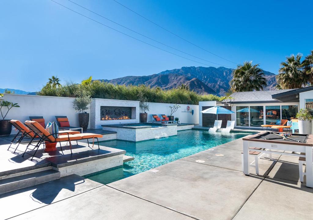 a house with a swimming pool with a fireplace at Luxury Desert Oasis in Palm Springs