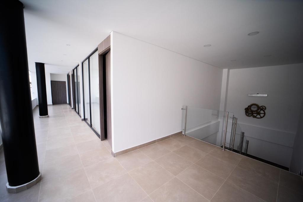 - un couloir avec des murs blancs et du carrelage dans l'établissement Hermosa habitación 4 personas, à Rozo