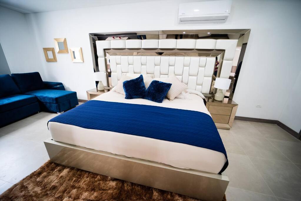 een slaapkamer met een groot bed en een blauwe bank bij luxury suite presidencial 