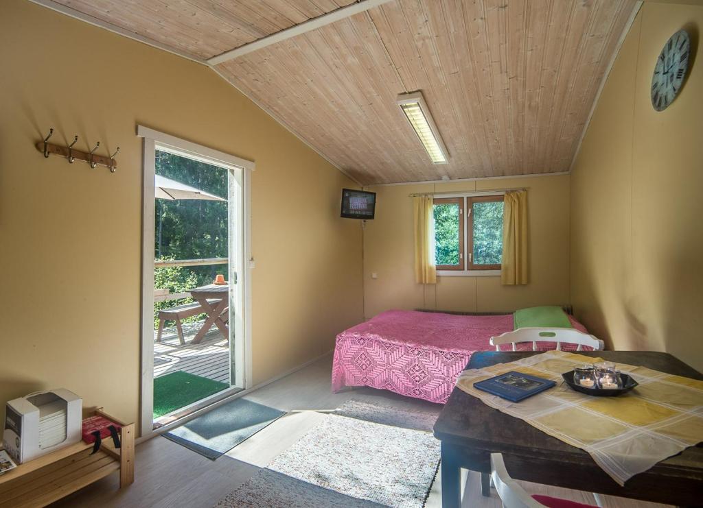1 dormitorio con 1 cama y 1 mesa en una habitación en Lammashaan tupa lammen rannassa, en Ruovesi