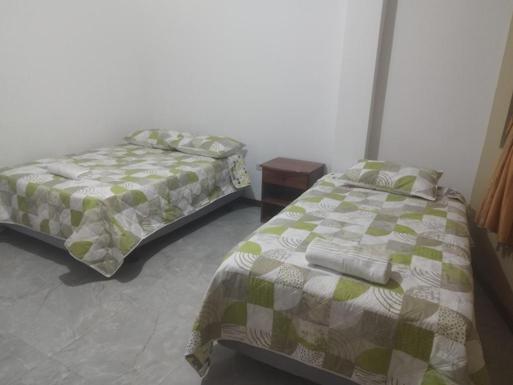 - une chambre avec 2 lits et une table de nuit dans l'établissement Casa D'Lucas, à Puerto Baquerizo Moreno