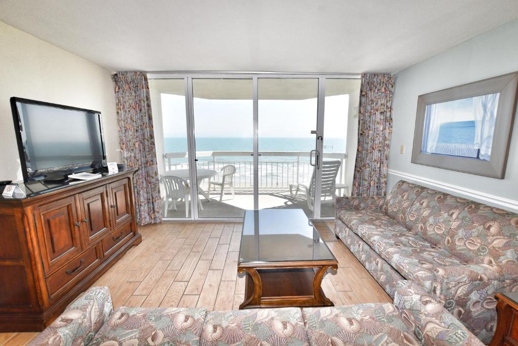 uma sala de estar com um sofá e uma televisão de ecrã plano em 0404 Waters Edge Resort condo em Myrtle Beach