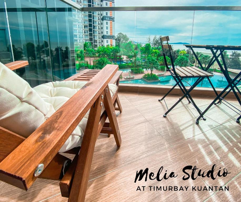 TimurBay Seafront Residences by Melia Studio في كُوانتان: غرفة معيشة مع طاولة خشبية وكرسي