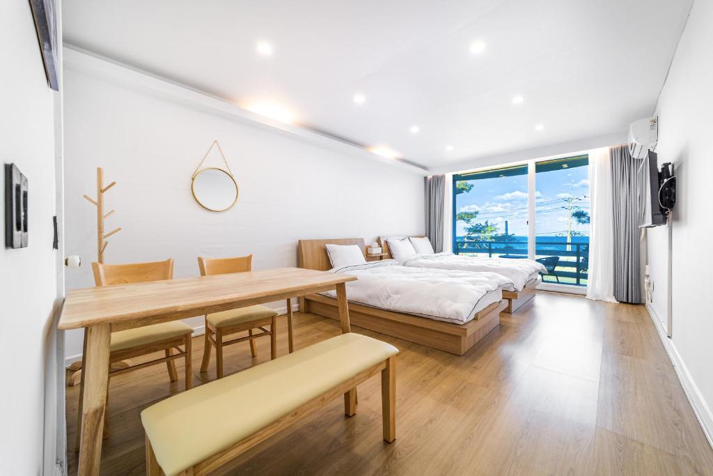 a bedroom with a table and a bed and a dining room at Sky Sea Pension in Yangyang