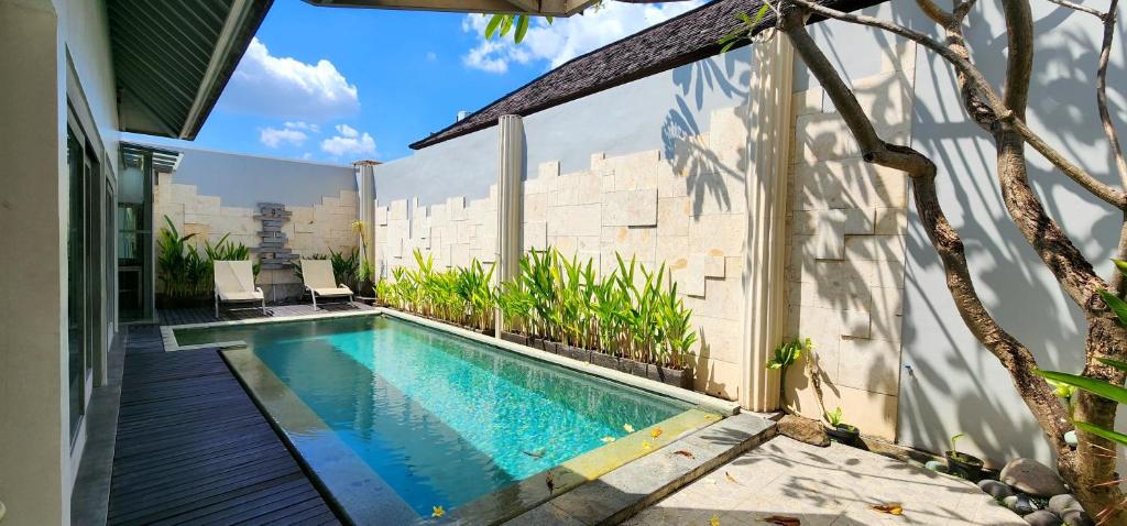a swimming pool in front of a house at Zoe Villa Canggu Bali in Canggu