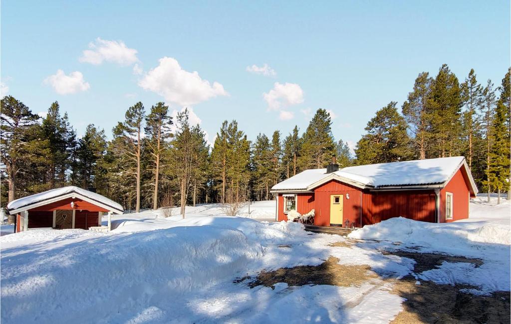 una cabaña roja en la nieve con árboles en el fondo en Amazing Home In Idre With Kitchen, en Storbo