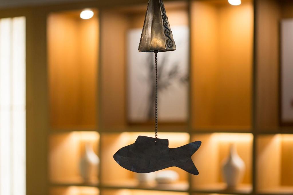 un adorno de pescado colgando en una habitación en Tomonoya Signature Ryokan Namhae en Namhae