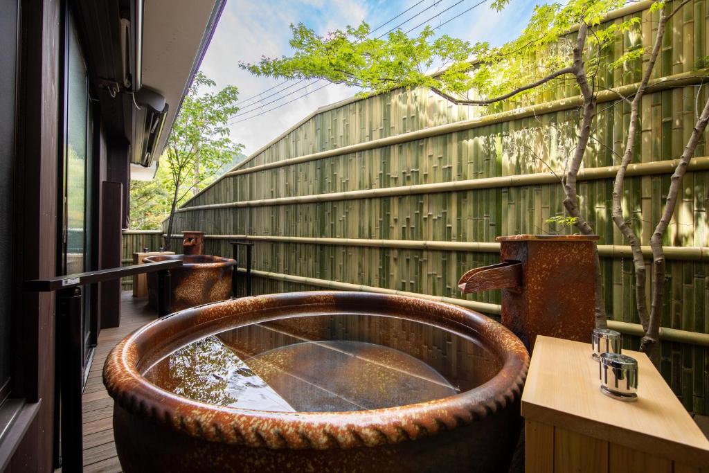 una vasca da bagno nel centro di un patio di Hachikan a Kyoto