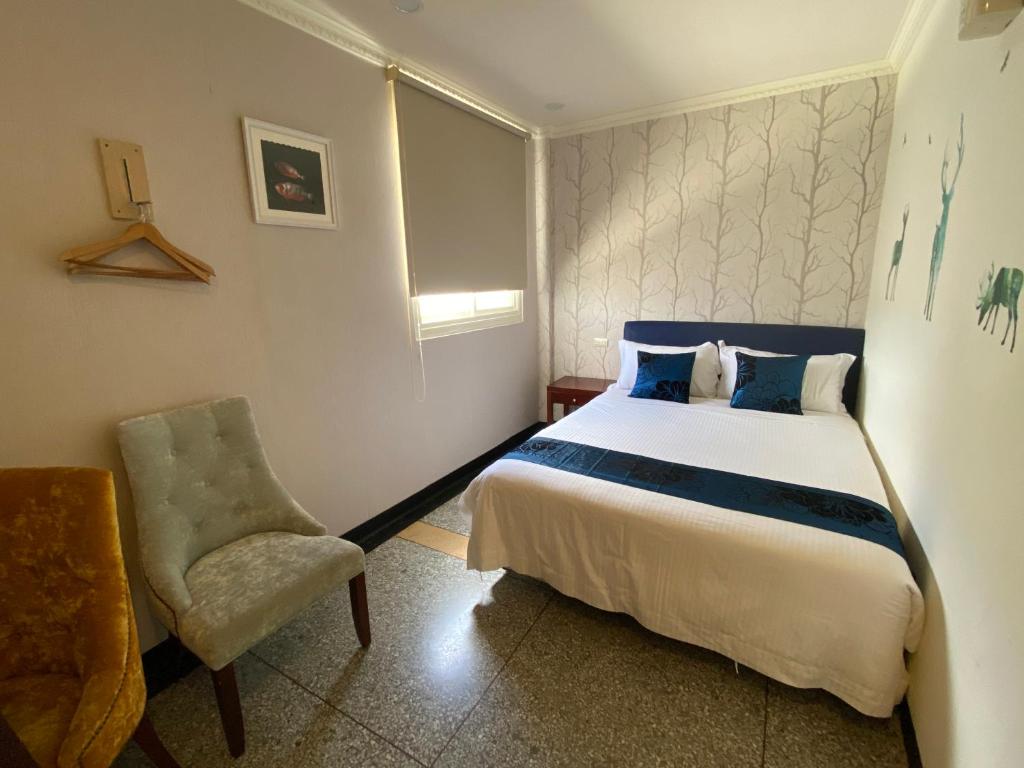 a bedroom with a bed and a chair at Kenting Heng-Chung Art Hostel in Hengchun