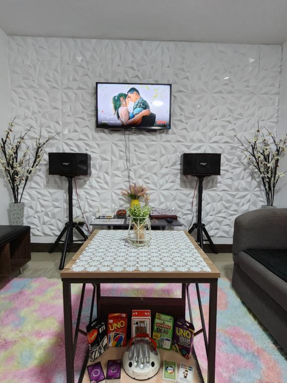 un soggiorno con tavolo e TV a parete di Marco's Lounge 1 a Imus