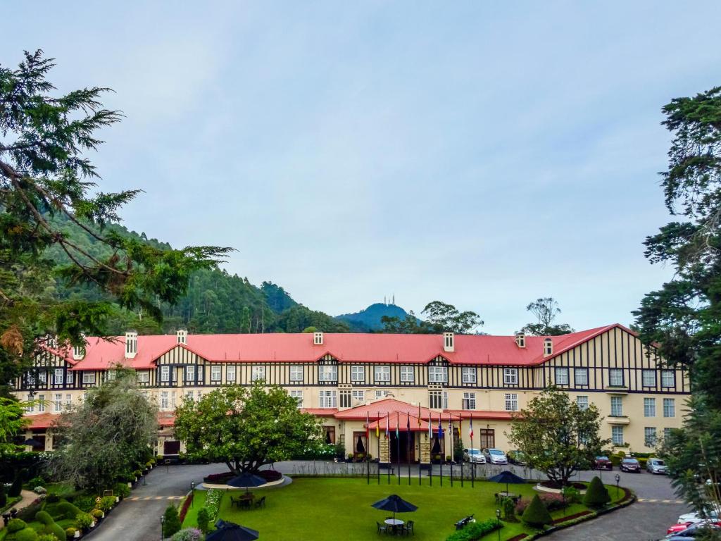 ein großes Gebäude mit rotem Dach in der Unterkunft The Grand Hotel - Heritage Grand in Nuwara Eliya