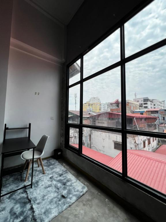 a room with a desk and a large window at liora Cambodia - Riverside Loft Apartments in Phnom Penh