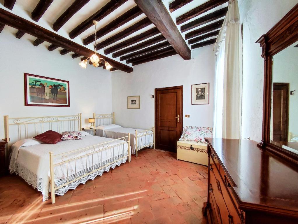 サン・ジミニャーノにあるIl Bacio Del Sole San Gimignano Apartmentsのベッドルーム1室(ベッド2台、テーブル付)